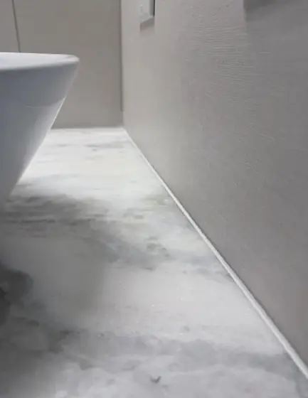 Clean caulk line between a marble floor and a wall