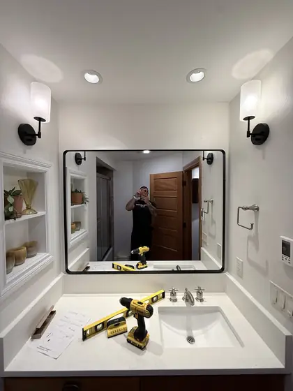 Wall mirror hung above a bathroom vanity